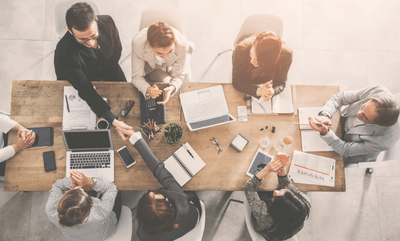 A group of women and men at a conference table making a business deal.